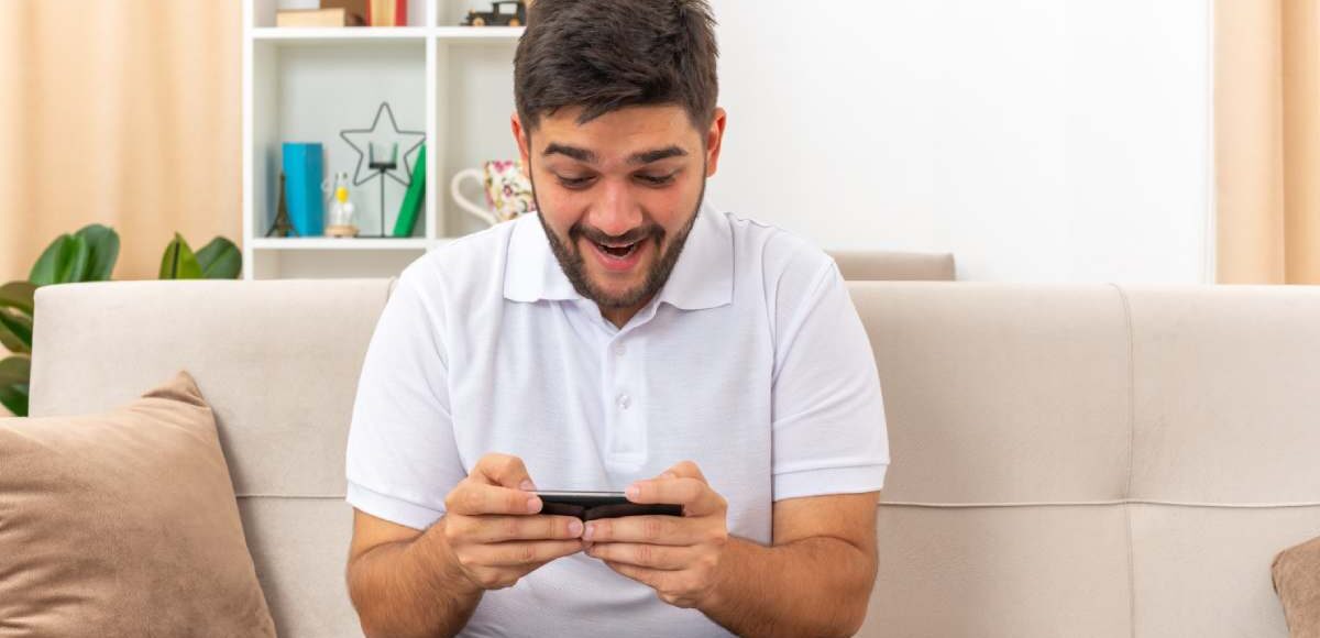 Joven en celular emocionado por sus apuestas en basketball