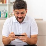 Joven en celular emocionado por sus apuestas en basketball