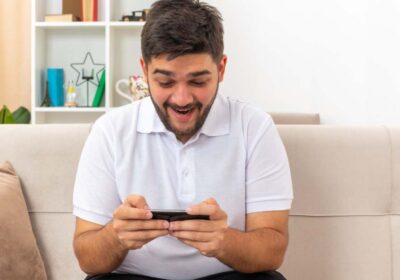 Joven en celular emocionado por sus apuestas en basketball