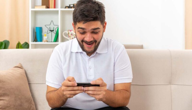 Joven en celular emocionado por sus apuestas en basketball