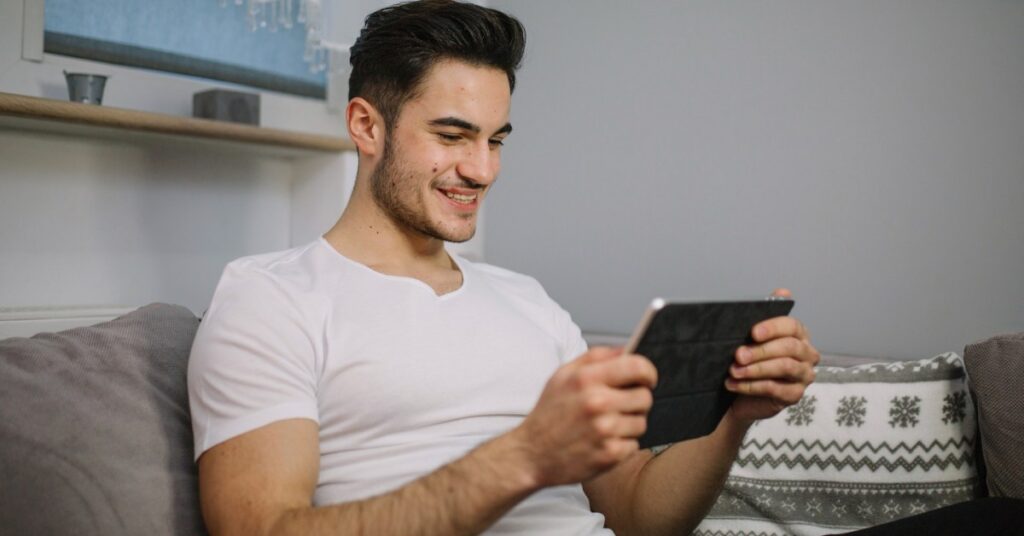 Joven en tablet hace seguimiento a su apuesta de carrera de caballos